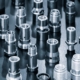 Close Up Of Various Metallic Threaded Fasteners On Dark Surface