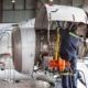 Worker Inspecting Jet Engine